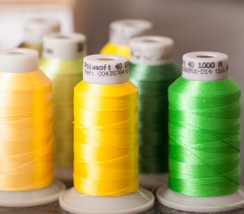 Garnrollen in verschiedenen Farben im Regal der Stickerei